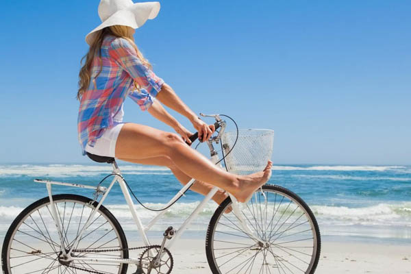 Female riding bike on the white sand beach from Mike's Bike Rental in Hilton Head 600